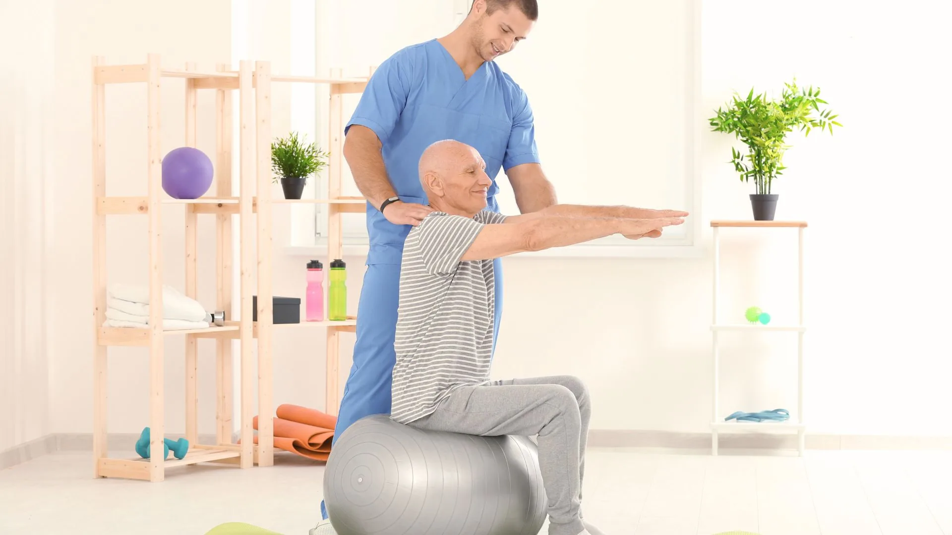 An older adult practicing seated balance and strength with one-on-one therapist support